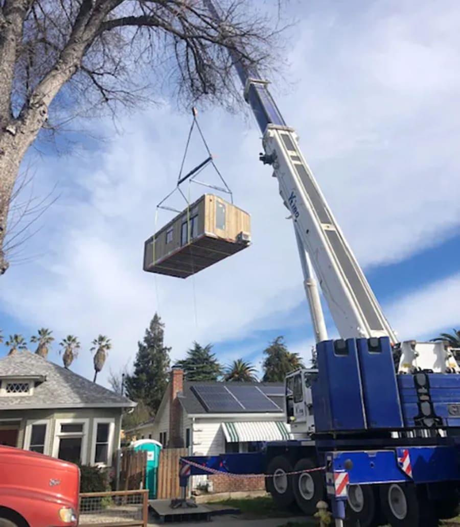 A large crane installs a backyard unit, which was built by Abodu, in Jeff Thomson’s backyard on Feb. 4, 2020, in San Jose, Calif.